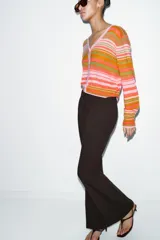 Pantalón de vestir color rosado, tiro bajo, con corte acampanado (flare) y costuras laterales marcadas. Cierre frontal con botón interior y gancho.