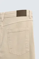 Pantalón de corte recto confeccionado en tejido de algodón con elasticidad. Presenta diseño de cinco bolsillos, cierre frontal con cremallera y botón.