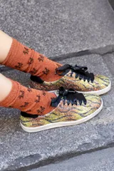 Zapatillas deportivas con estampado de tigre, cordones de raso negros y detalles en ante negro en el talón.