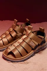 Sandalias tipo trekking color beige, con tiras de nylon ajustables y suela técnica con diseño ergonómico y detalles multicolor en la base.