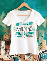 Remera blanca de manga corta y escote en V, con diseño artístico estampado en el frente que incluye la palabra "AWESOME" en color negro sobre bloques abstractos en tonos turquesa y beige, y salpicaduras oscuras.