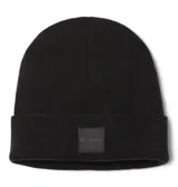 Gorro tipo beanie de punto acanalado en color negro, con diseño de puño enrollado y parche cuadrado frontal con el logo de la marca Columbia.
