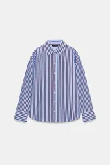 Camisa de corte clásico con cuello solapa y manga larga, confeccionada en tejido oxford con diseño de rayas verticales en azul y bordó. Presenta cierre frontal con botones y bajo con aberturas laterales.