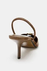 Zapato destalonado color marrón con efecto desgastado, punta fina, tira trasera ajustable y tacón fino de 7 cm.