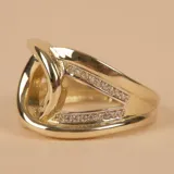 Anillo de oro 10k con diseño de nudo central y bandas laterales decoradas con pequeñas circonias engastadas.