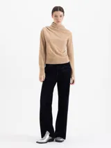 Sweater de lana merino color negro, con cuello medio alto y detalle de frunces en los hombros que aportan volumen. De calce regular y tejido suave.