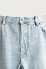 Pantalón jeans de corte recto, color celeste claro con efecto lavado, de cinco bolsillos y tiro medio.