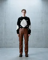 Buzo tejido a mano con diseño de rombos en contraste blanco y negro, cuello redondo y mangas largas.