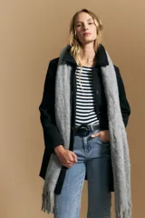 Tapado de paño negro con cuello amplio, estructura recta y cierre frontal con botones. Diseño minimalista y elegante.