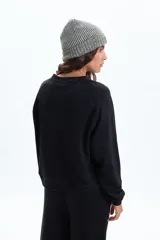 Buzo deportivo negro de manga larga, con cuello redondo y corte holgado.