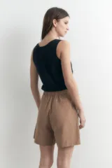 Short de vestir color camel, tiro alto, con pliegues frontales y bolsillos laterales.