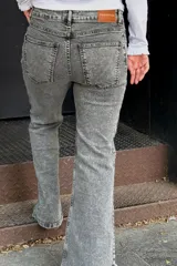 Jean de corte wide leg en color gris con efecto lavado. Presenta tiro medio-alto, costuras verticales frontales y tajos en el ruedo de ambas piernas.