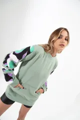 Buzo verde con mangas estampadas en negro, blanco, verde y lila.