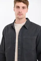 Sobrecamisa gris oscuro de manga larga, con cuello clásico, cierre frontal con botones y dos bolsillos de parche en el pecho.