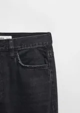 Jeans Matilda de tiro medio y corte recto, confeccionados en tejido denim de algodón color negro. Presenta diseño clásico de cinco bolsillos, trabillas para cinturón y cierre frontal con cremallera y botón metálico.