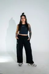 Pantalón de corte holgado y estilo urbano, color negro, con cintura elástica ajustable mediante cordón y bolsillos laterales. Presenta un pequeño estampado en la pierna derecha.