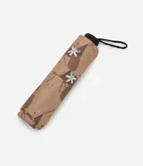 Sombrilla pequeña unisex de poliéster, color beige con estampado de carpinchos y flores blancas. Cuenta con apertura manual, cabo con regulador y correa de mano. Incluye forro a juego.