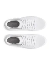 Championes Under Armour modelo W Official, de diseño minimalista en color blanco total. Presentan una parte superior de cuero sintético con el logo de la marca grabado en el lateral, cierre de cordones y suela de plataforma estable.