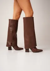 Botas negras de caña alta confeccionadas en cuero vegano, con punta fina y taco cuadrado.