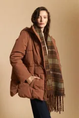 Campera acolchada de nylon en color crema, con capucha ajustable, cierre frontal con botones y cordón de ajuste en la cintura.