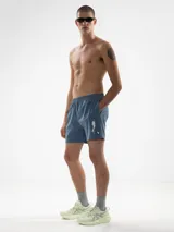 Short de baño negro con bordado de enredadera blanca en la pierna izquierda. Cuenta con cintura elástica con cordón ajustable, bolsillos laterales y bolsillo trasero con cierre. Incluye suspensor de malla fina hipoalergénico.