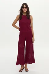 Pantalón de punto color bordó con diseño geométrico y estructura calada, de corte ancho y relajado.