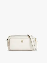 Cartera tipo cámara Tommy Hilfiger color beige, con acabado texturizado, monograma TH en bajo relieve y herrajes dorados. Cuenta con correa cruzada ajustable y extraíble, cierre de cremallera y un bolsillo exterior.