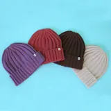 Gorro tipo beanie de tejido de punto acanalado en color violeta, con doblez en el borde y etiqueta pequeña con logo N+.