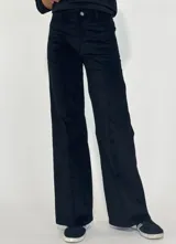 Pantalón de corte recto y tiro medio, confeccionado en pana color bordó. Presenta costuras verticales decorativas en el frente, cierre con botón y bolsillos laterales.