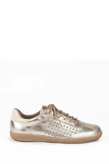 Championes deportivos de cuero natural color dorado, con perforaciones laterales para mayor ventilación, cordones al tono y suela de goma plana.