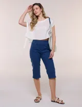 Capri de denim blanco con pretina ancha elastizada, tiro alto, bolsillos simulados al frente y bolsillos funcionales en la parte posterior, con pequeños tajos laterales en el bajo.