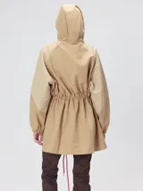 Campera tipo piloto con capucha, cierre frontal con botones y detalle de costuras en zigzag. Presenta cordones ajustables en la cintura y capucha, puños elásticos y logo bordado en el pecho.