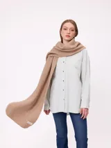 Bufanda de tejido de punto grueso en color negro, con etiqueta de la marca Rusty en uno de los extremos.