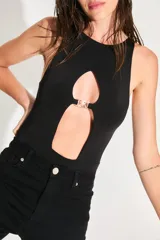 Body negro de seda fría con escote cerrado y abertura en el delantero unida por un aplique metálico con el logo de la marca.