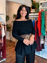 Polerón oversize de tejido de punto color naranja, con cuello alto tipo polera, mangas largas con puños acanalados y bolsillos laterales. Presenta un detalle de etiqueta de cuero en la parte inferior.