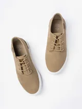 Zapatilla urbana de gamuza sintética color tostado, con cordones al tono y suela de goma blanca.