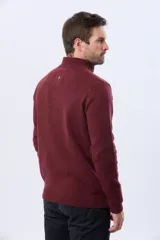 Buzo tejido de lana con cuello alto y medio cierre metálico frontal. Presenta puños y ruedo acanalados, con logo bordado en el pecho.