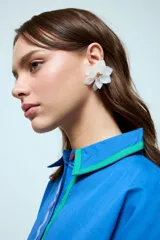 Caravanas tipo clip con diseño de flor de pétalos blancos de resina y centro metálico dorado.