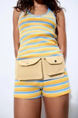 Top de punto con cuello halter y espalda descubierta, con diseño de rayas horizontales en tonos amarillo, naranja y celeste, y detalles de vivos en contraste.