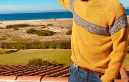 Sweater mostaza de lana merino con diseño de franja diagonal con patrón geométrico en tonos grises.