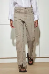 Jean color visón confeccionado en algodón sin spandex. Detalle de costura delantera con pespunte color óxido, tajo en tobillo y desflecado abajo y en bolsillos.