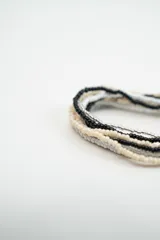 Set de pulseras elásticas compuestas por múltiples hileras de cuentas de vidrio en tonos turquesa, coral, blanco y dorado.