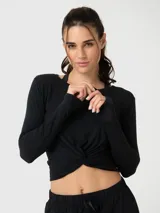 Polera de manga larga color negro, confeccionada en modal, con diseño de nudo frontal y corte cropped.