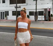 Short pollera blanco con diseño superpuesto de tela transparente con bordado floral de lentejuelas.