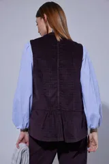 Chaleco de pana color bordó, con cierre frontal de botones y bolsillos laterales.