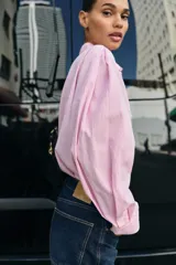 Camisa de algodón con estampado de rayas verticales en color rosado y blanco, cuello solapa y manga larga.