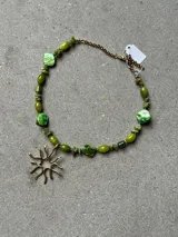 Collar de piedras naturales en tonos verdes con dije colgante de bronce con diseño orgánico.