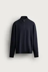 Jersey de punto regular fit de algodón color negro, con cuello perkins y cierre frontal de cremallera corta. Cuenta con mangas largas y acabados en rib.