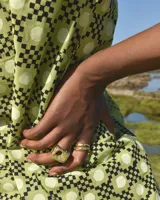 Anillo dorado con forma irregular y un agujero en el centro.