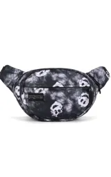 Riñonera JanSport modelo Fifth Avenue, color negro con estampado tie-dye en blanco y negro, con figuras que asemejan calaveras o caras sonrientes.